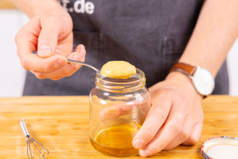 Honig-Senf Dressing zubereiten.