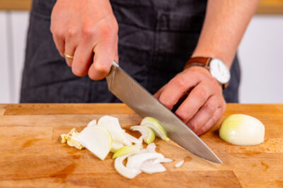 Zwiebel und Knoblauch in Streifen schneiden