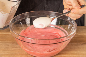 Sahne unter das Himbeermousse heben