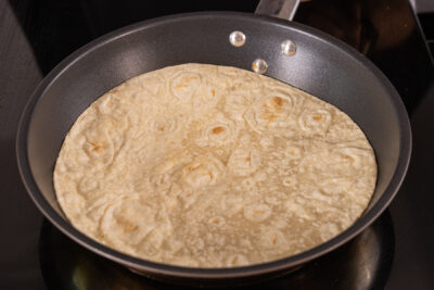 Tortilla in die Pfanne legen