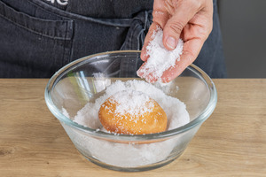 Krapfen mit Zucker bestreuen