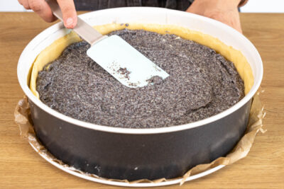 Mohn-Pudding-Masse auf dem Teigboden verteilen