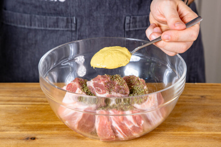 Senf zum Schweinefleisch geben