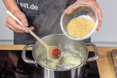 Orzo in den Topf geben