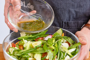 Dressing zum Salat geben