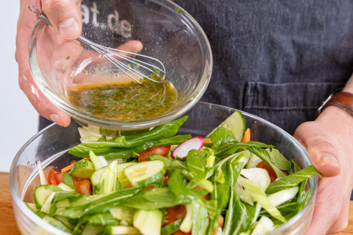 Dressing zum Salat geben