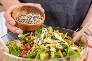 Sesam über den Pak-Choi-Salat streuen