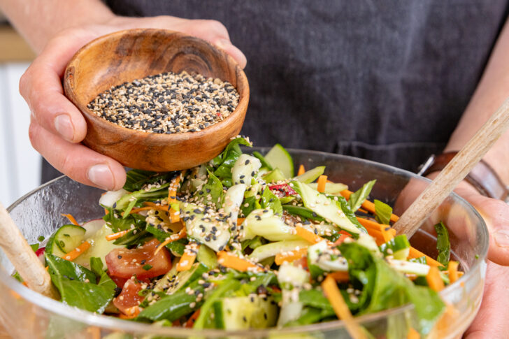 Sesam über den Pak-Choi-Salat streuen