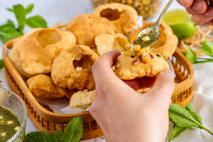 Pani Puri mit Minz-Wasser beträufeln