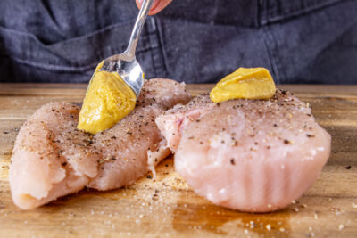 Senf auf das Fleisch geben