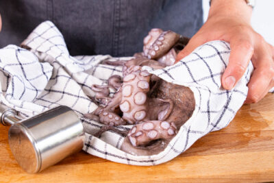 Pulpo mit einem Fleischklopfer weichklopfen