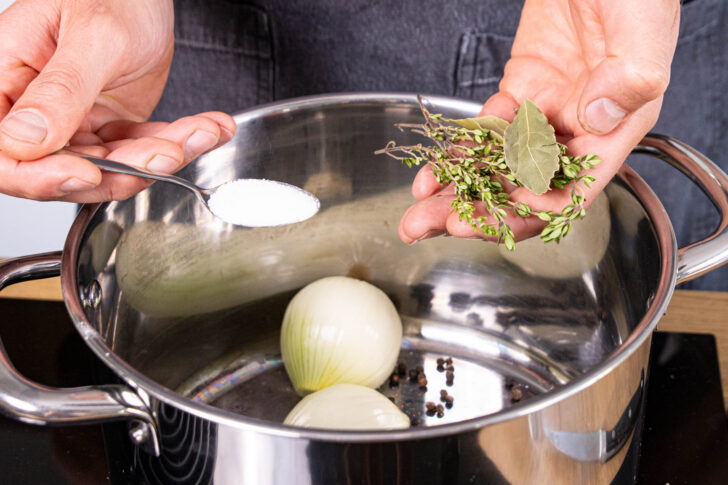 Gewürze, Zwiebeln und Knoblauch in einen großen Topf geben