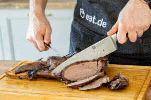 Rehfleisch vor dem Servieren vom Knochen lösen und in Steaks schneiden
