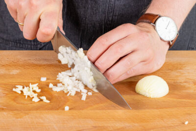 Zwiebel und Knoblauch in Würfel schneiden