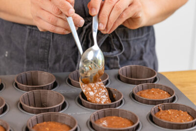 Teig auf Muffinsförmchen verteilen