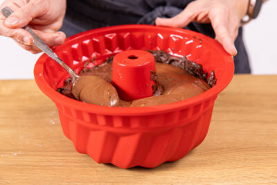 Dunklen Teig auf der Käsekuchenmasse verteilen
