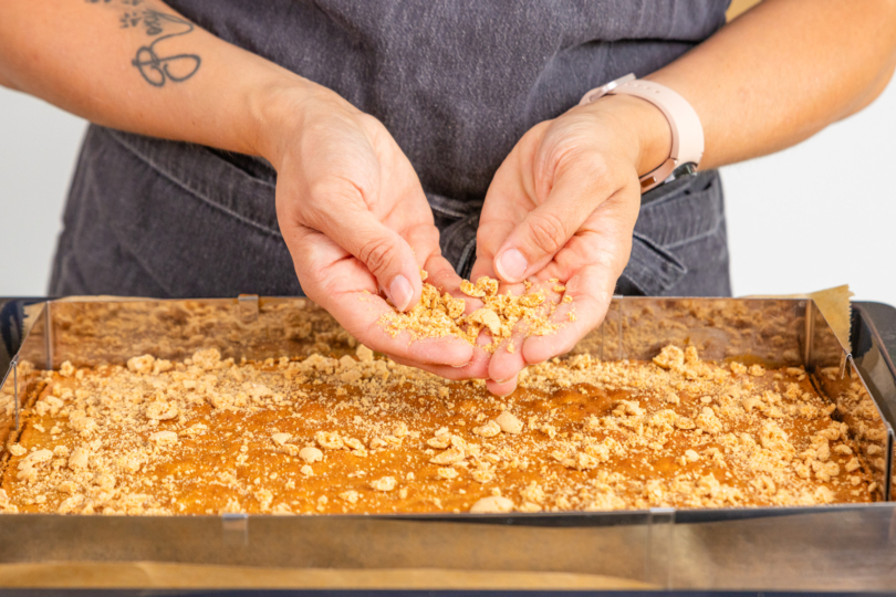 Amarettini zerbröseln und auf Kuchenboden verteilen