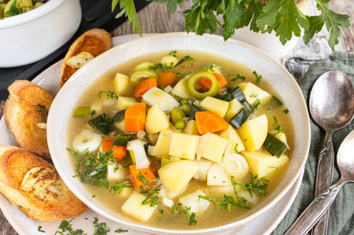 Vegetarischer Kartoffeleintopf mit Gemüse mit Baguette servieren