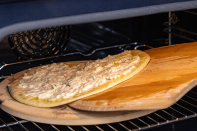 Weiße Pizza Bianca in Backofen schieben