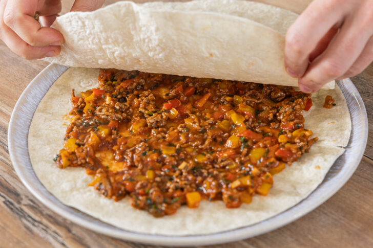 Tortillas und Hackfleischmasse schichten