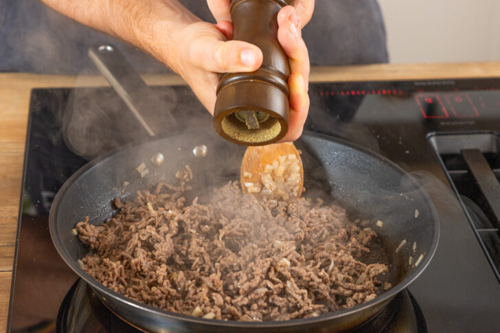 Hackfleisch mit Pfeffer würzen