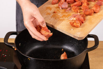 Fleisch für den Bigos in den Bräter geben