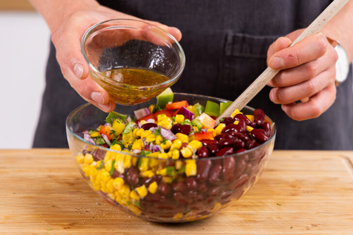 Dressing zu dem Salat geben