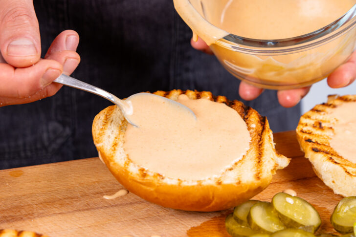 Burgerbrötchen mit Burgersauce bestreichen