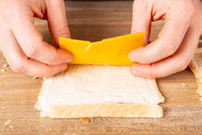 Toast platt rollen und Cheddar darauflegen