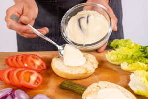 Sauce auf das Burgerbrötchen geben