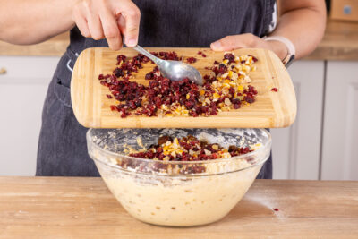 Orangeat und Cranberrys zum Früchtekuchen-Teig geben