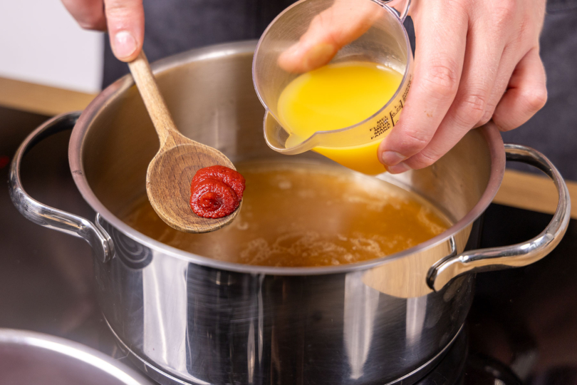 Tomatenmark und Saft zur Sauce geben