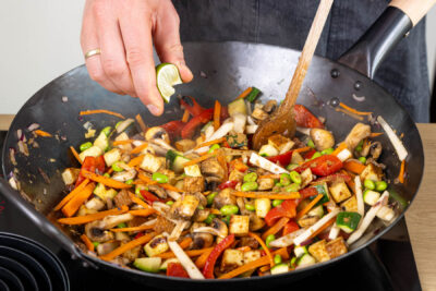 Gemüsepfanne mit Räuchertofu würzen und abschmecken