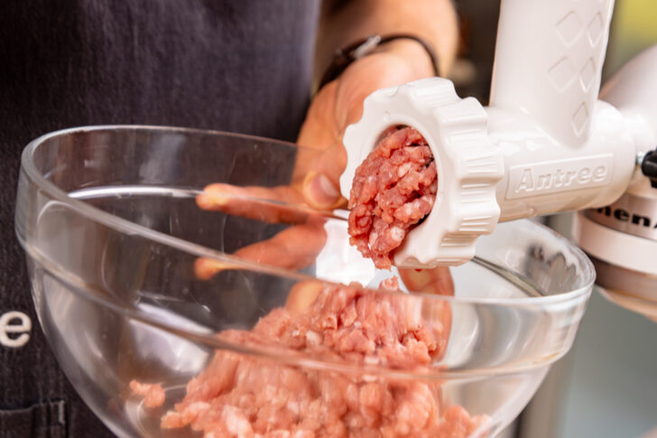 Schweinefleisch durch den Fleischwolf lassen