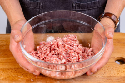 frisches Hackfleisch in Schüssel geben
