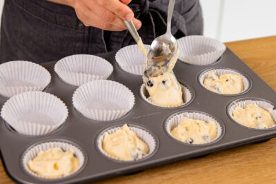 Teig für Heidelbeer Muffins in Muffinformen verteilen
