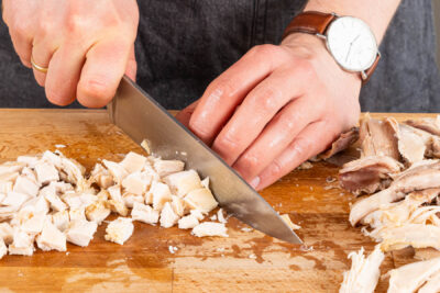 Hühnerfleisch abzupfen in Würfel schneiden