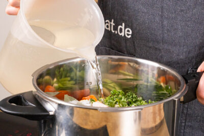 Wurzelgemüse und Wasser in den Schnellkochtopf geben