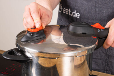 Schnellkochtopf verschließen und Suppenhuhn darin kochen