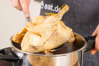 Suppenhuhn aus dem Schnellkochtopf nehmen