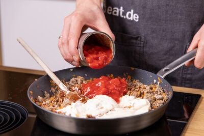 Gehackte Tomaten aus der Dose dazugeben