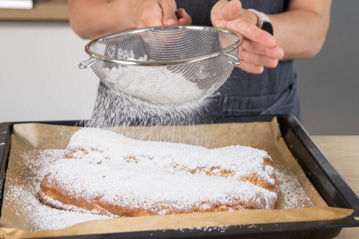 Stollen mit Puderzucker bestäuben