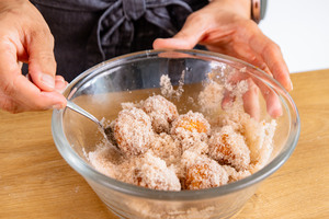 Mutzenmandeln in Zucker-Zimt-Mischung wälzen
