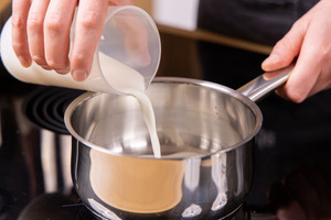 Milch in den Topf gießen