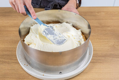 Creme auf dem Tortenboden verstreichen