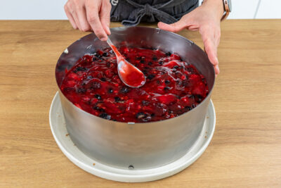Beerenmasse auf der Rote-Grütze-Torte verteilen