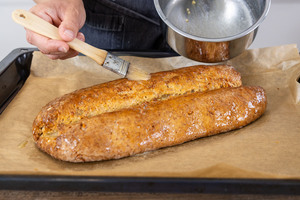 Mandelstollen mit Butter bestreichen