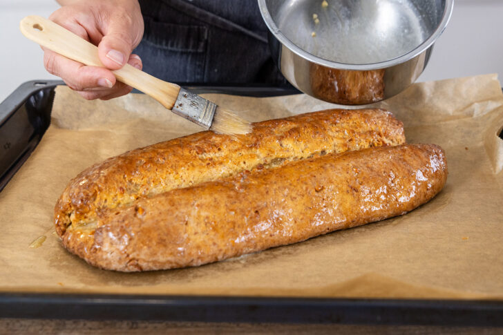 Mandelstollen mit Butter bestreichen