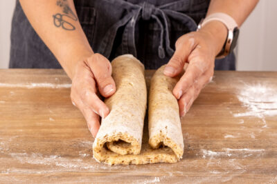 Teig zu Mandelstollen zusammenrollen