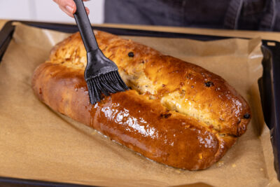 Gebackenen Marzipanstollen mit Butter einstreichen
